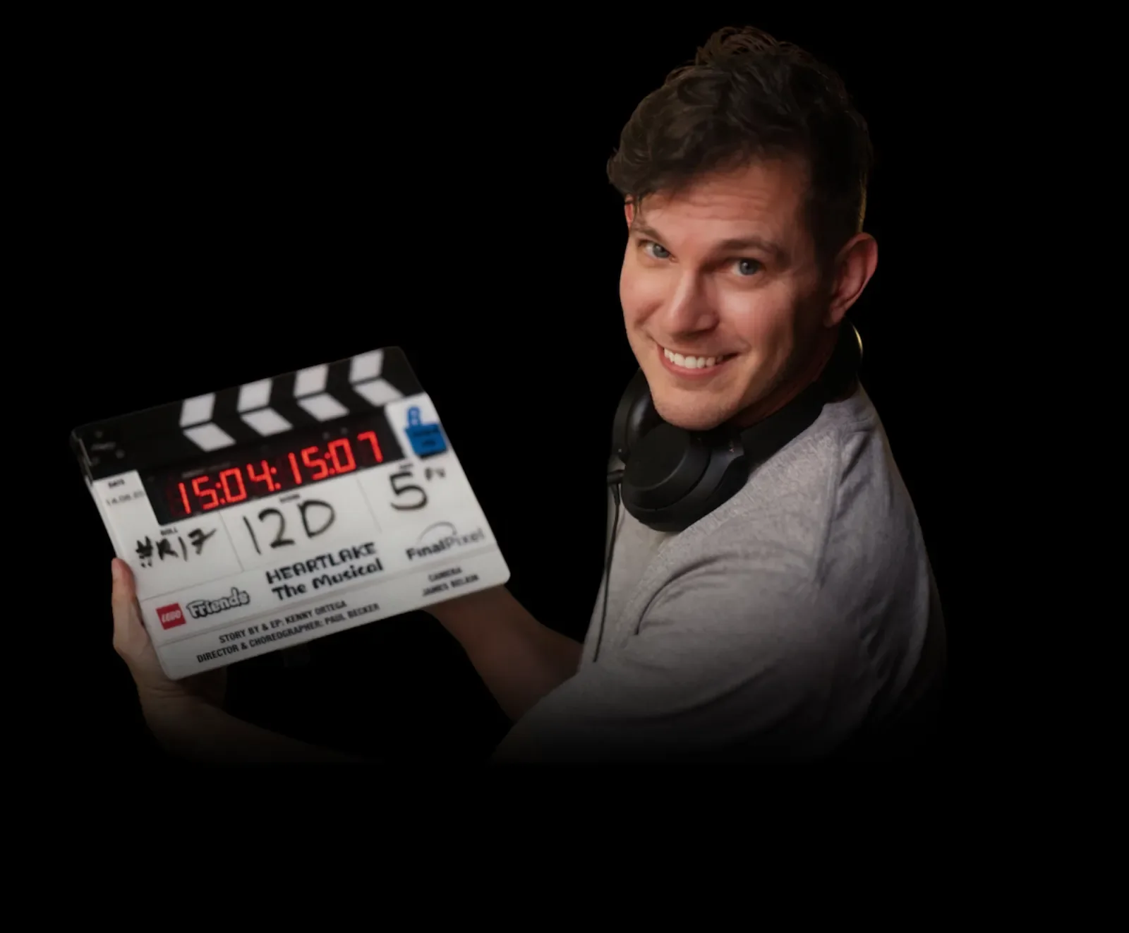 Paul Becker on the set of LEGO Friends: Heartlake the Musical, holding the clapperboard